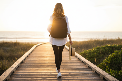 Model with black backpack on outdoor trail